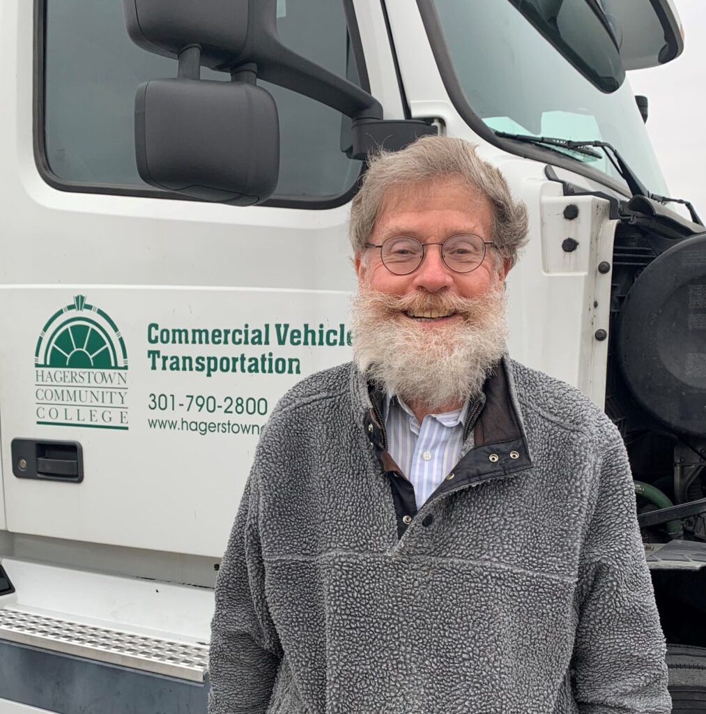 Mike Stevenson smiling in front of a Hagerstown Community College truck