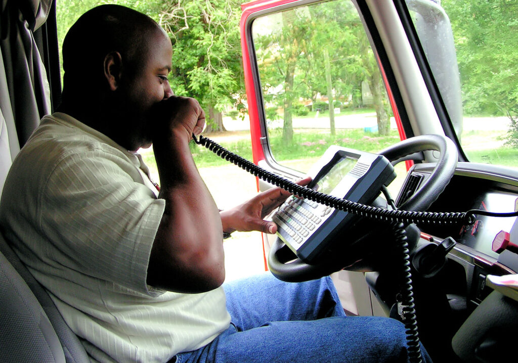 Guy speaking into radio inside a truck
