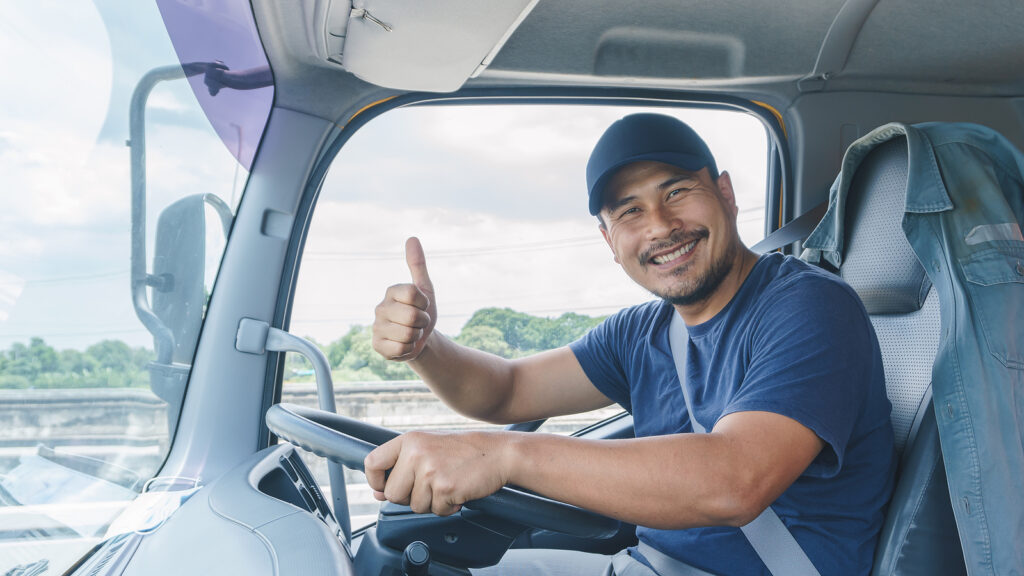 Driver with thumbs up in driver's seat of a truck